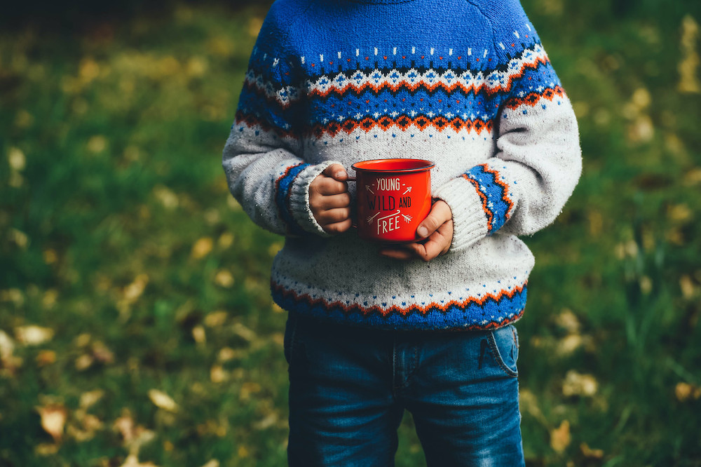 kid in sweater with coffee mug