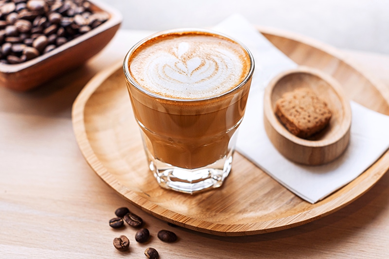 Cortado coffee served with biscuit
