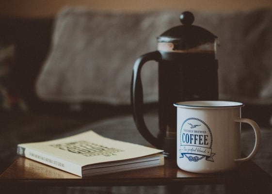 a french press and a coffee mug