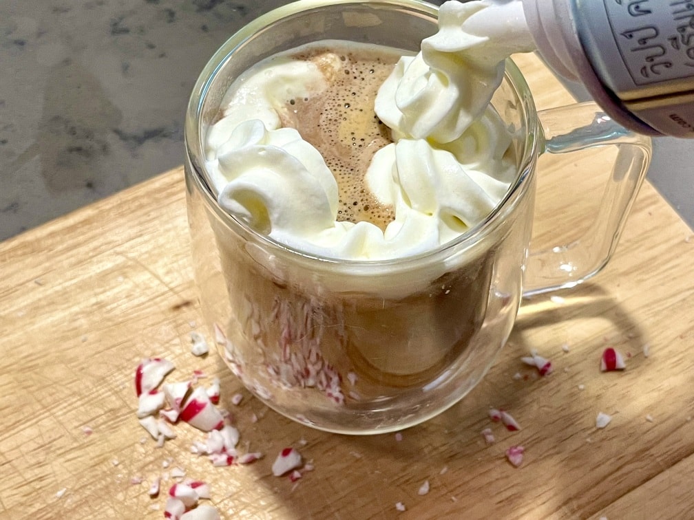 starbucks peppermint mocha at home adding the whipped cream and garnish