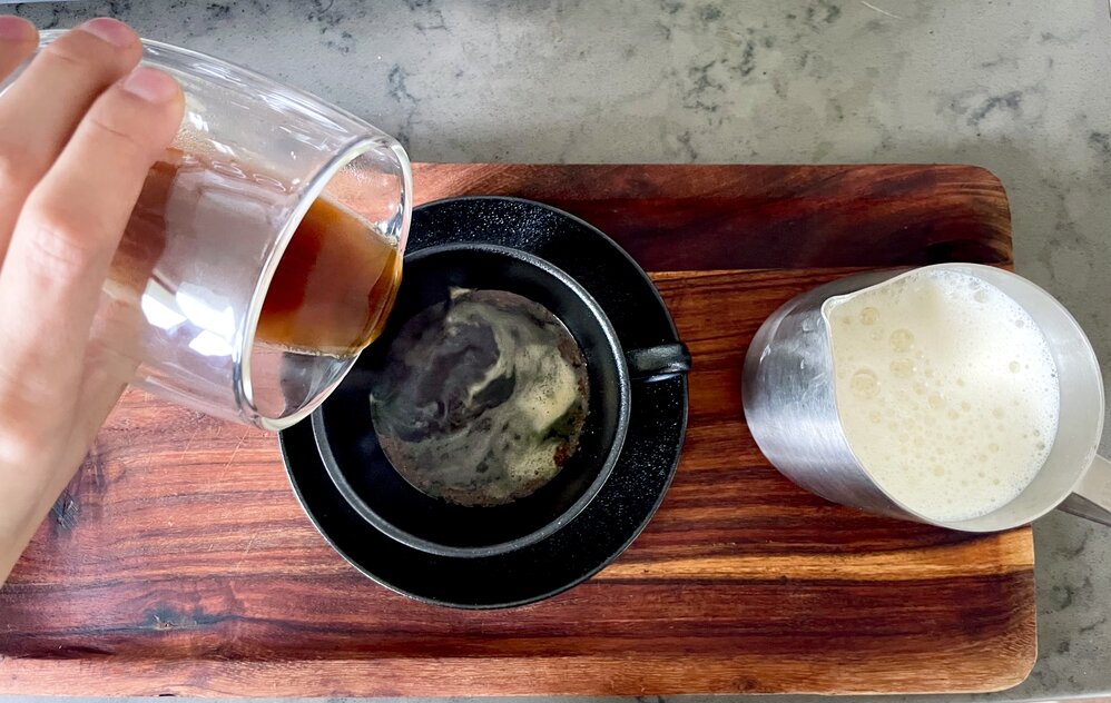 pouring espresso over syrup and spices for maple latte