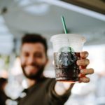 man holding a starbucks drink