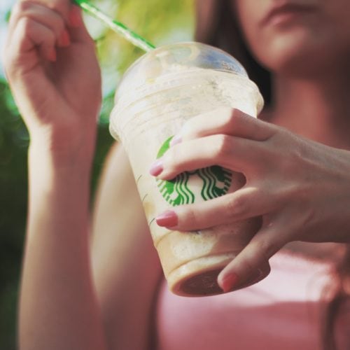 person holding a starbucks drink
