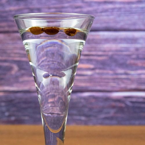 a glass of Sambuca with three coffee beans