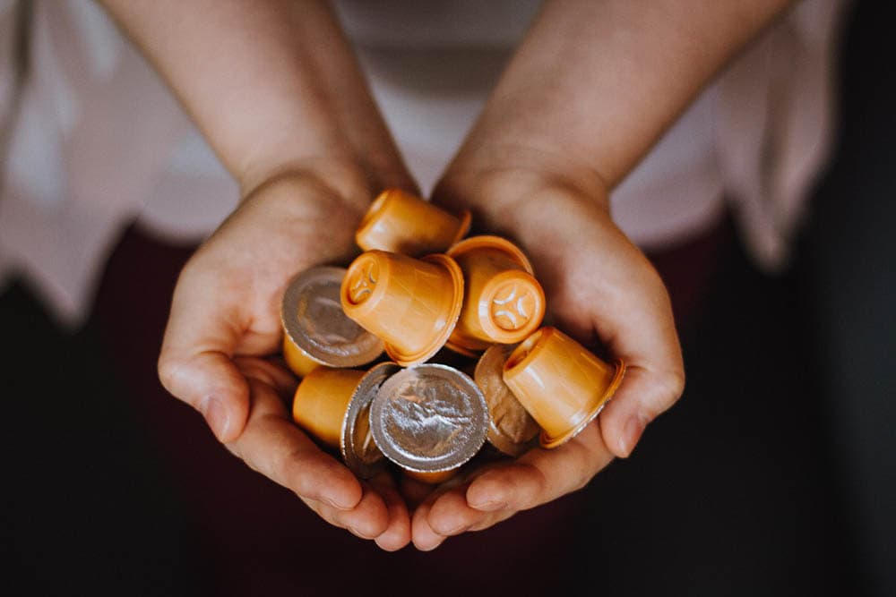 person holding coffee capsules
