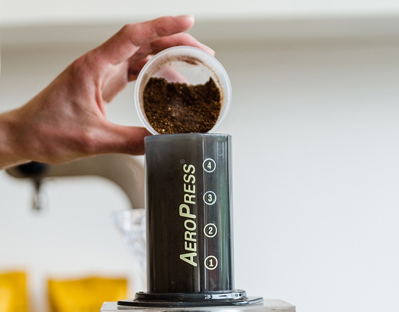 person pouring coffee in aeropress