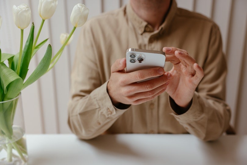 a cropped person holding a phone