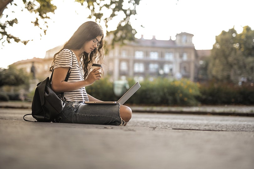 a female with coffee working on her laptop
