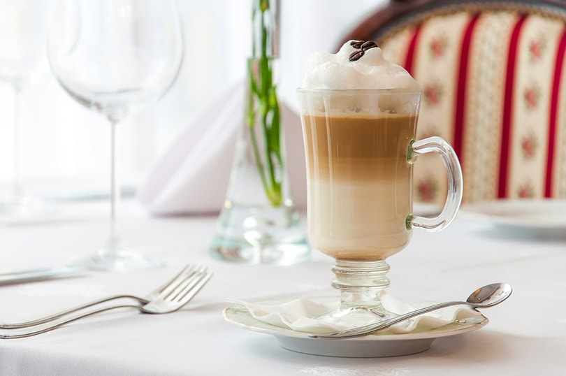 a glass of latte macchiato on white table