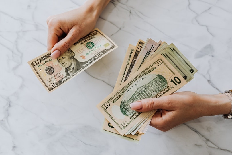 hands holding us dollar bills