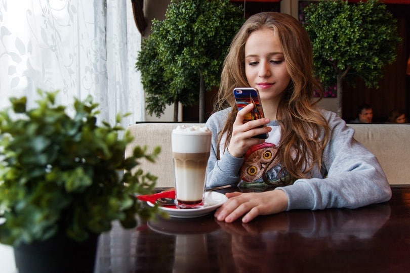 teenager taking a photo of her coffee drink