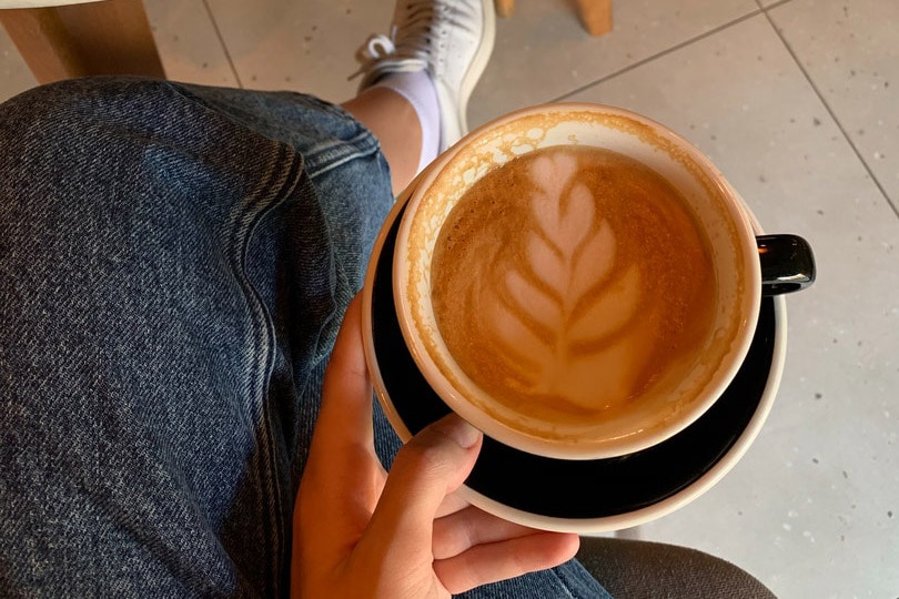 cropped woman holding a cup of coffee on a saucer