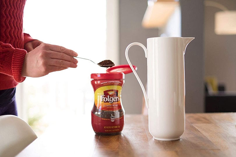 woman preparing folgers coffee