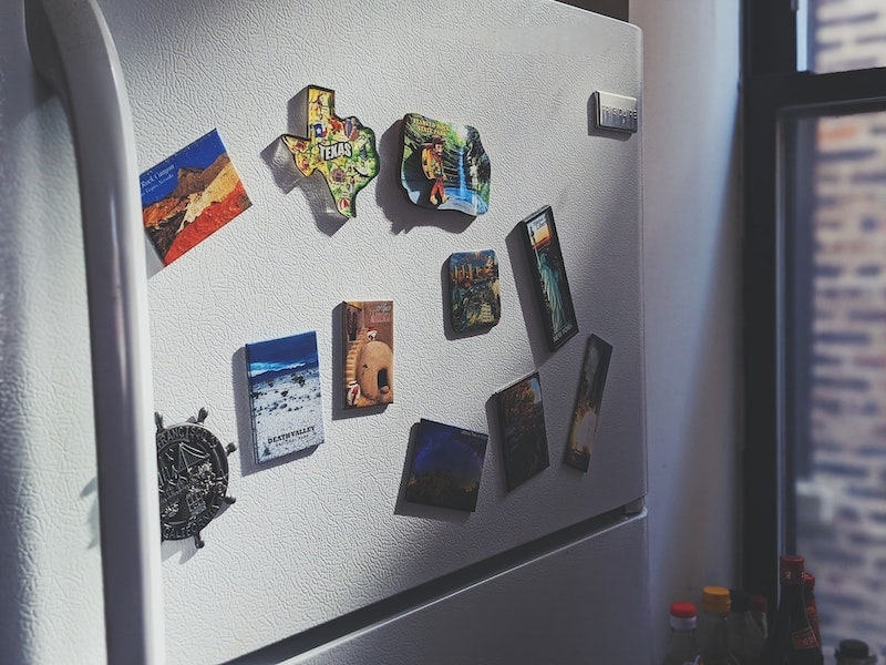 refrigerator covered in magnets