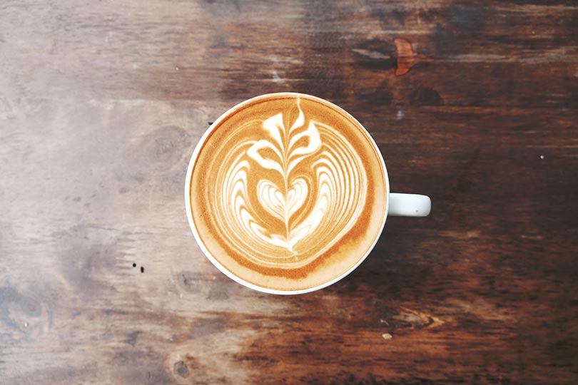 a cup of coffee on wooden table