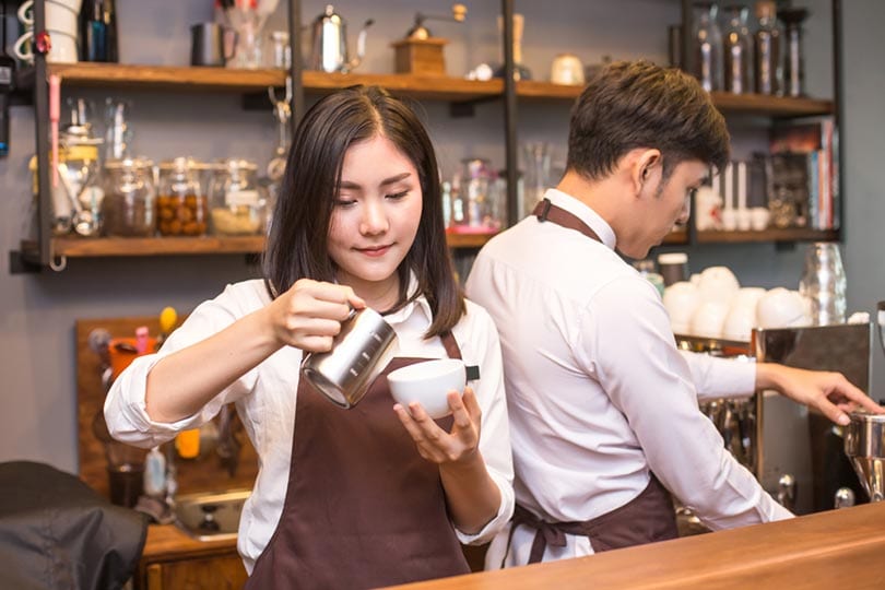 asian female barista making coffee in coffee shop