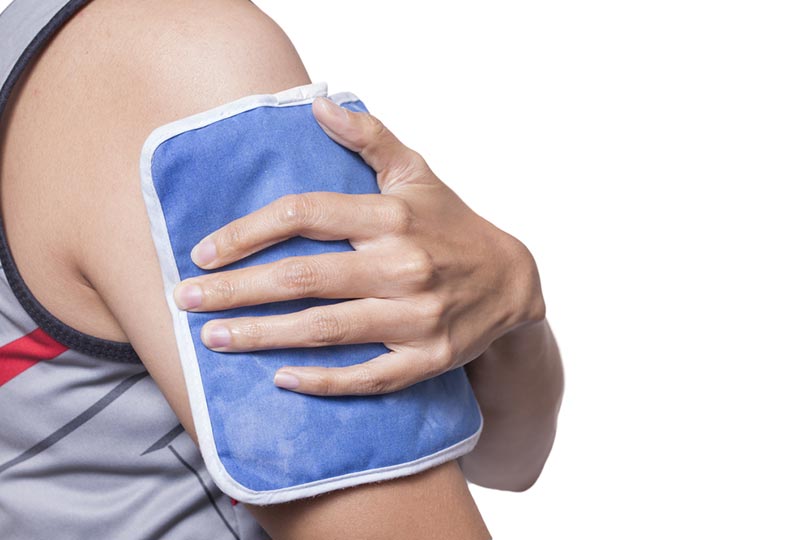 woman putting an ice pack on her shoulder pain