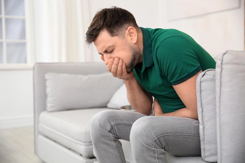 young man having nausea at home