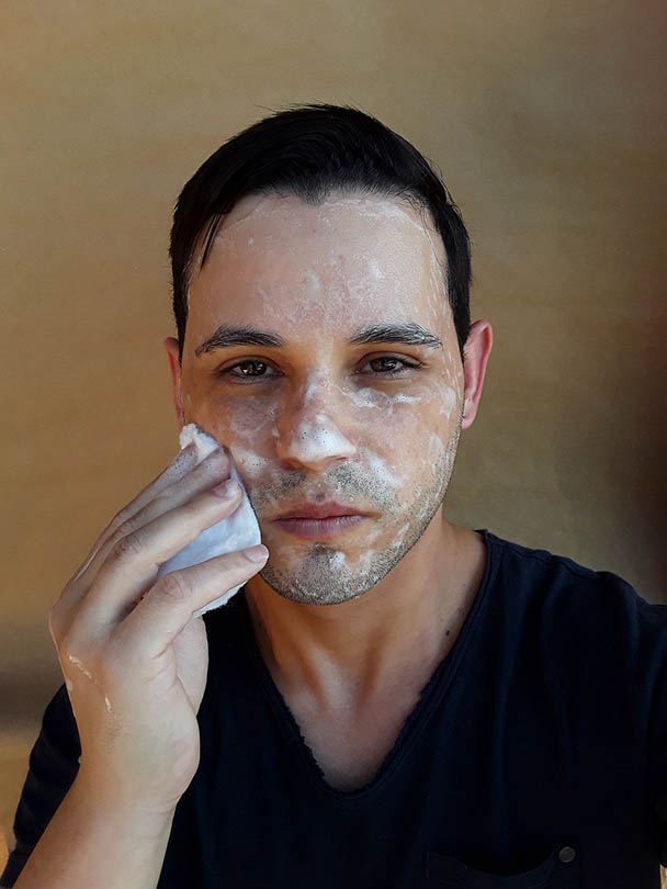 man cleansing his face