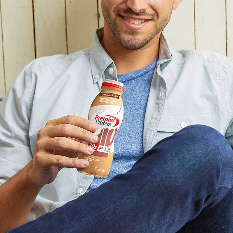 man holding a bottle of Premier Protein Shake Rootbeer Float flavor