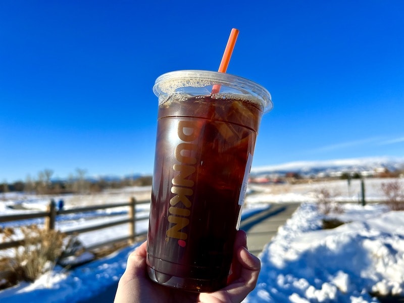 Dunkin iced coffee outside with straw_Kate