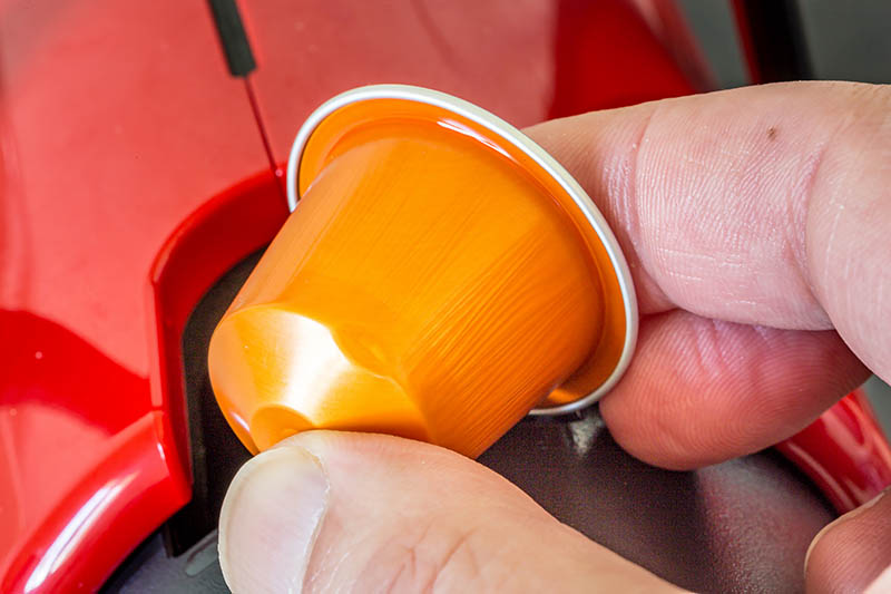 putting nespresso capsule to the machine