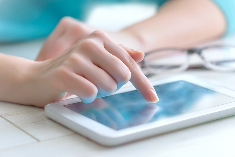 hand touching screen on tablet