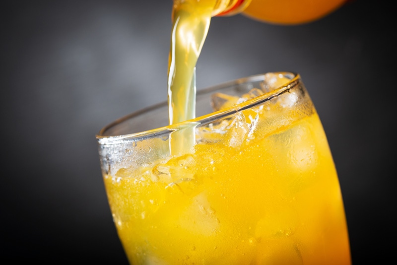 pouring orange soda into glass