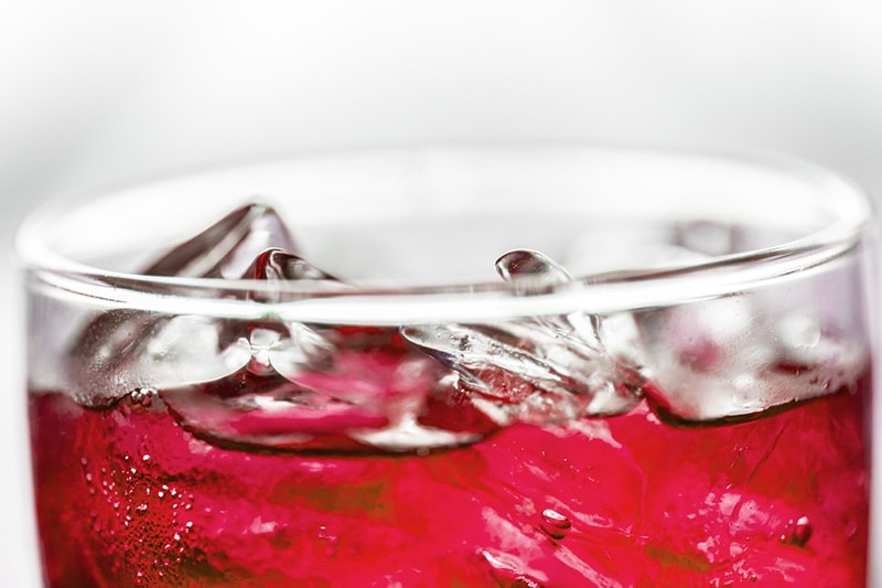 red soda in a glass with ice