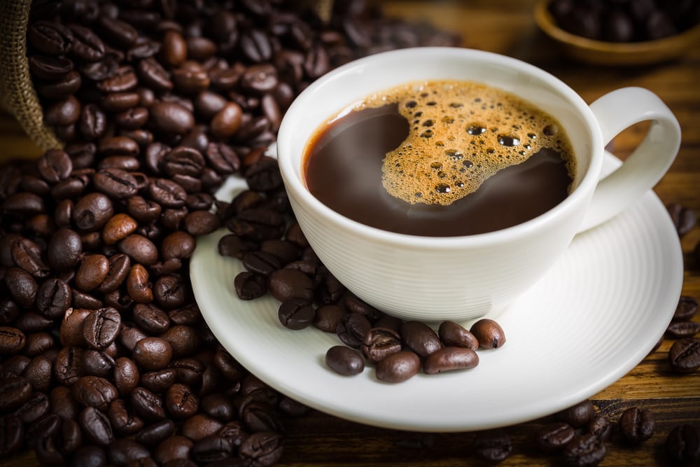 coffee cup and beans on wooden table